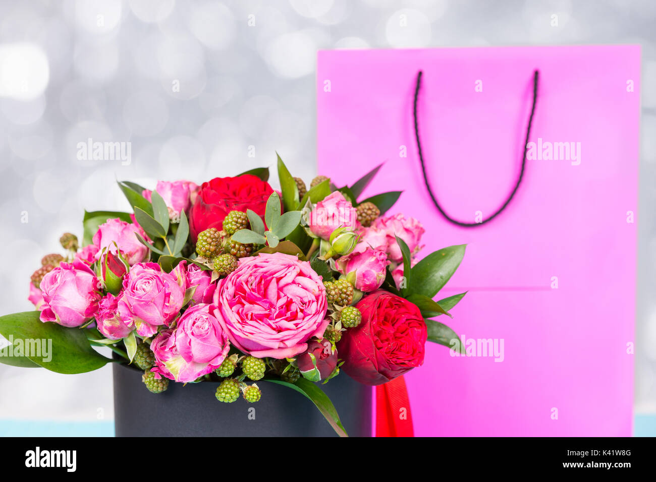 Beautiful bouquet of pink and red roses and red ribbon in a circular ...