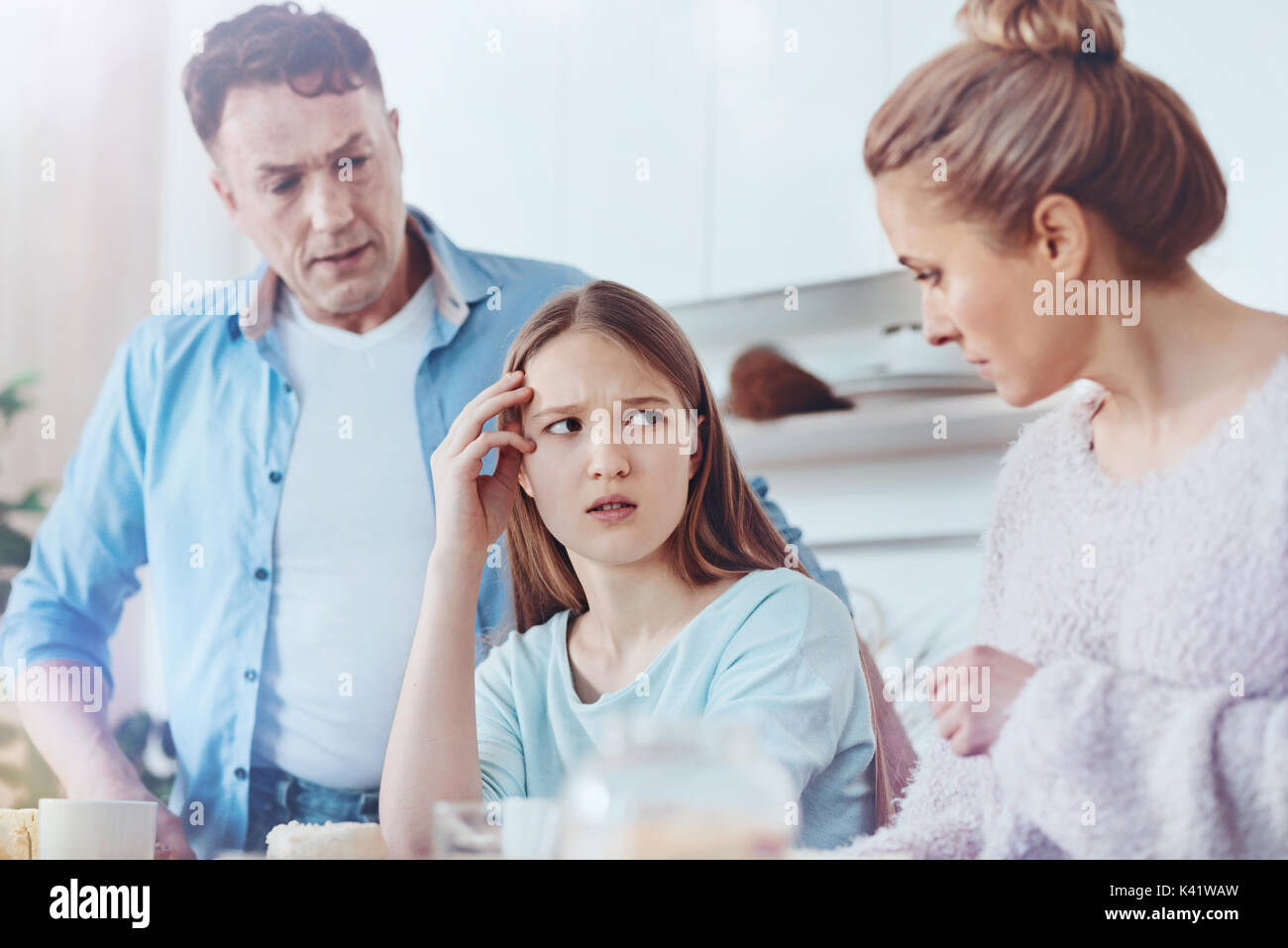 Scared parents discussing misbehavior of their daughter Stock Photo