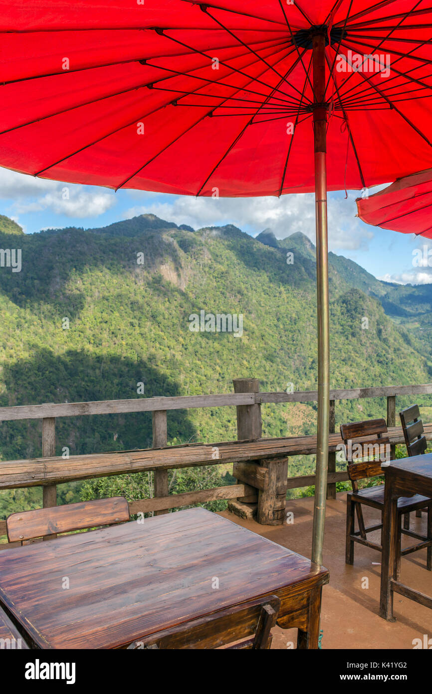 Beautiful outdoor cafe with traditional red Thai umbrellas in Northern Thailand. Stock Photo