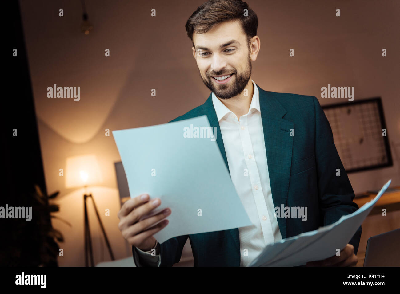 Positive delighted brunette reading documents Stock Photo