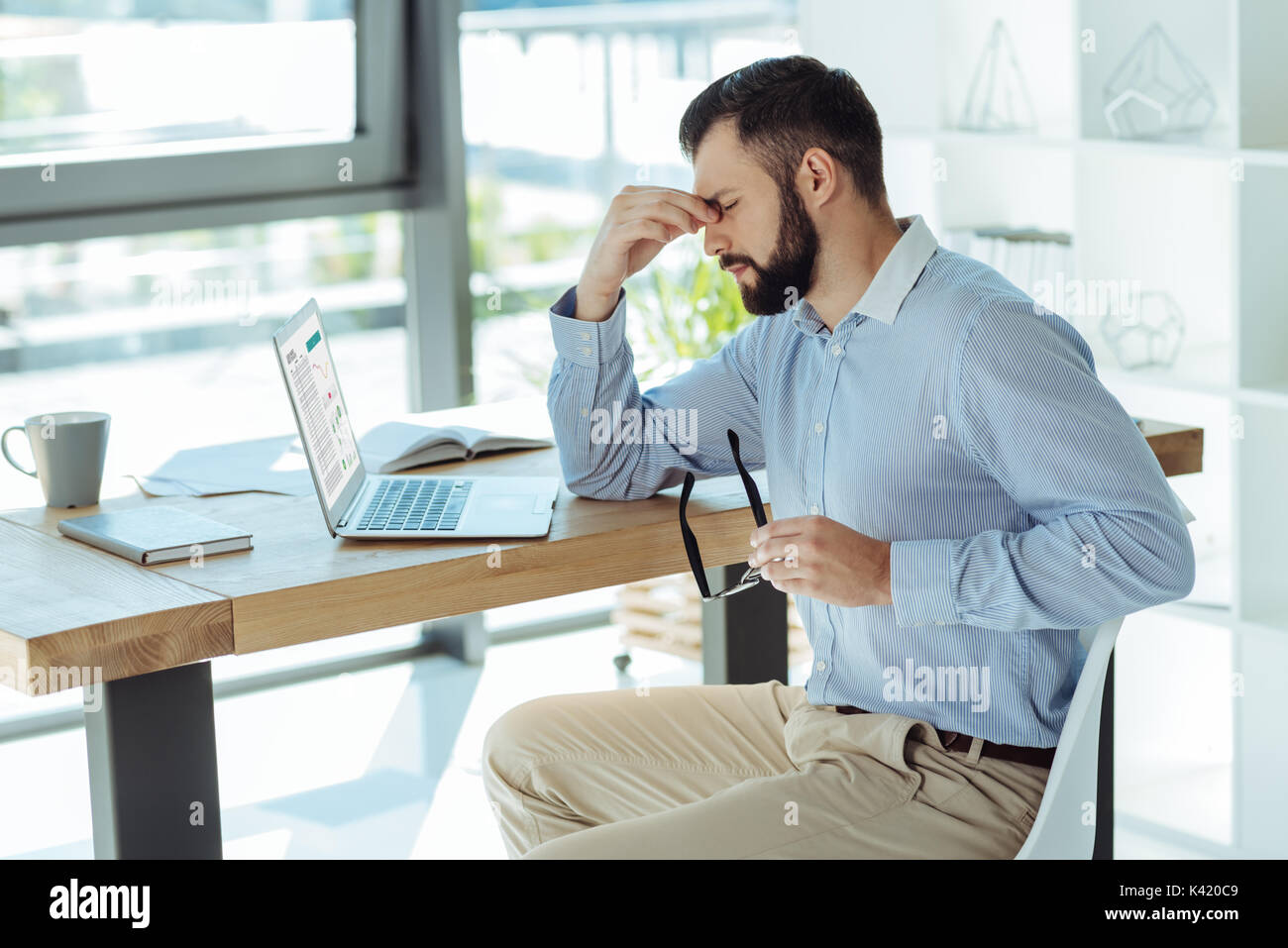 Tired businessman pinching bridge of nose Stock Photo Alamy
