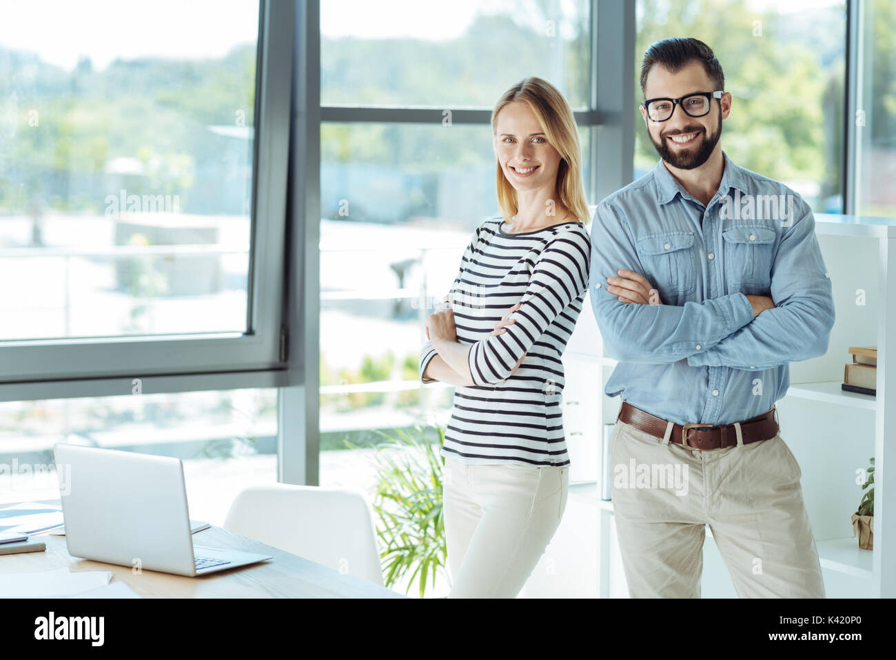 Charming woman and handsome man posing in the office Stock Photo - Alamy