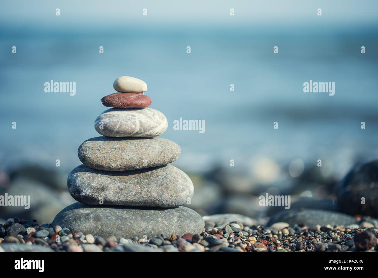 zen-like stones on beach under sun. soft focus Stock Photo