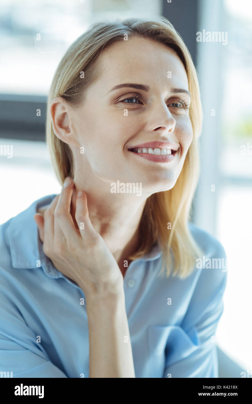 Portrait of a dreamy young woman touching her neck Stock Photo - Alamy