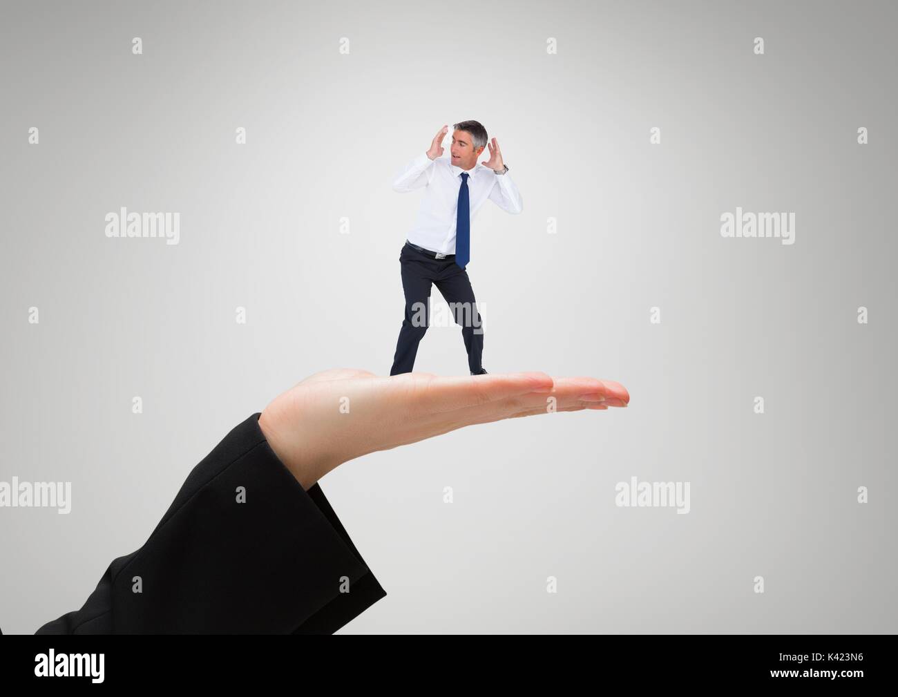 Digital composite of Small business man standing on the big business woman hand Stock Photo