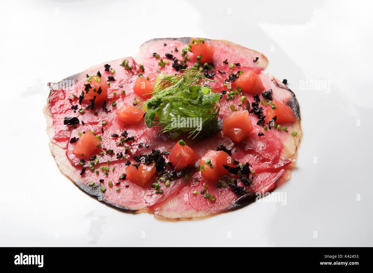 forefront of carpaccio of tuna with diced tomatoes Stock Photo Alamy