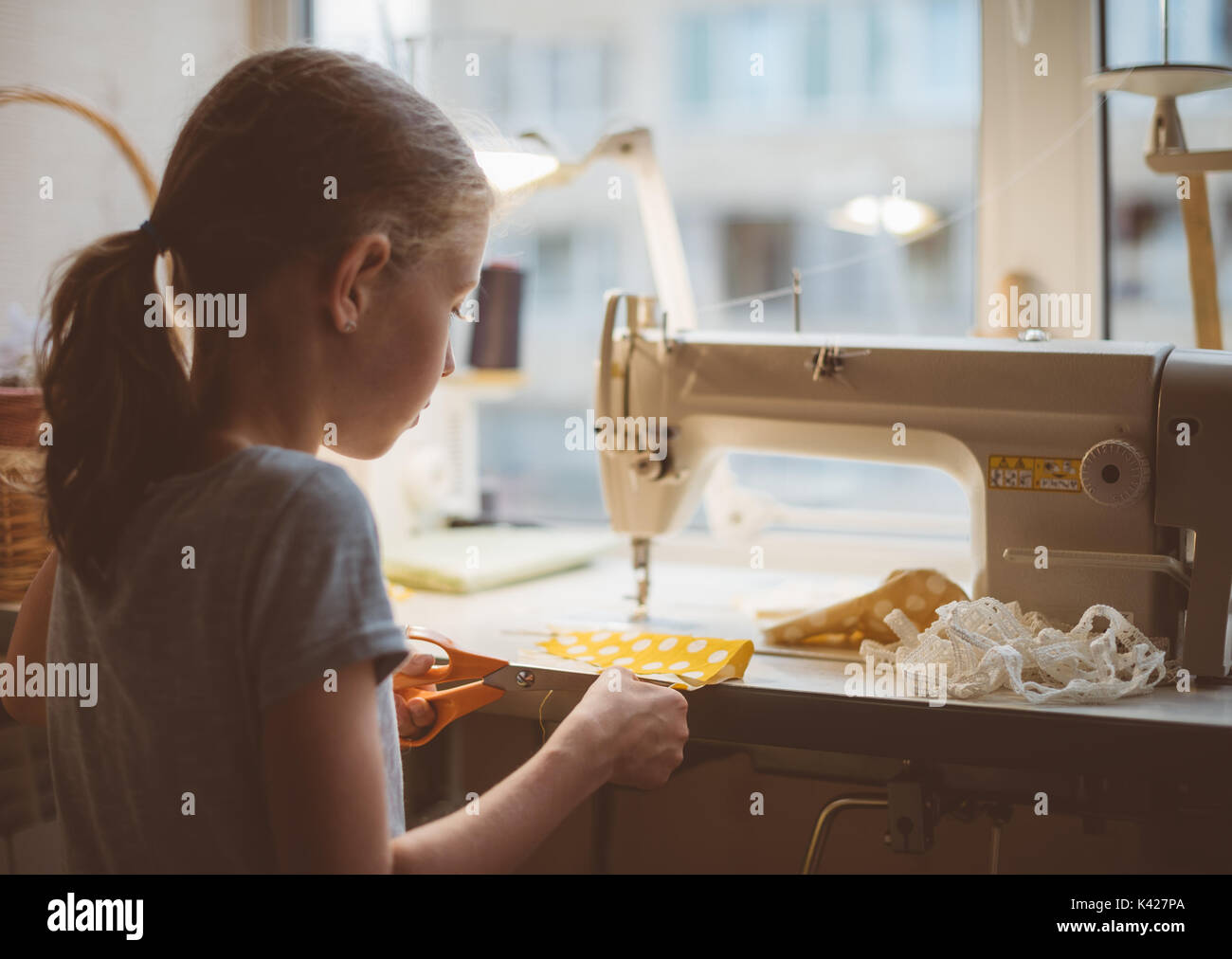 Little girl working on sewing machine at home Stock Photo Alamy