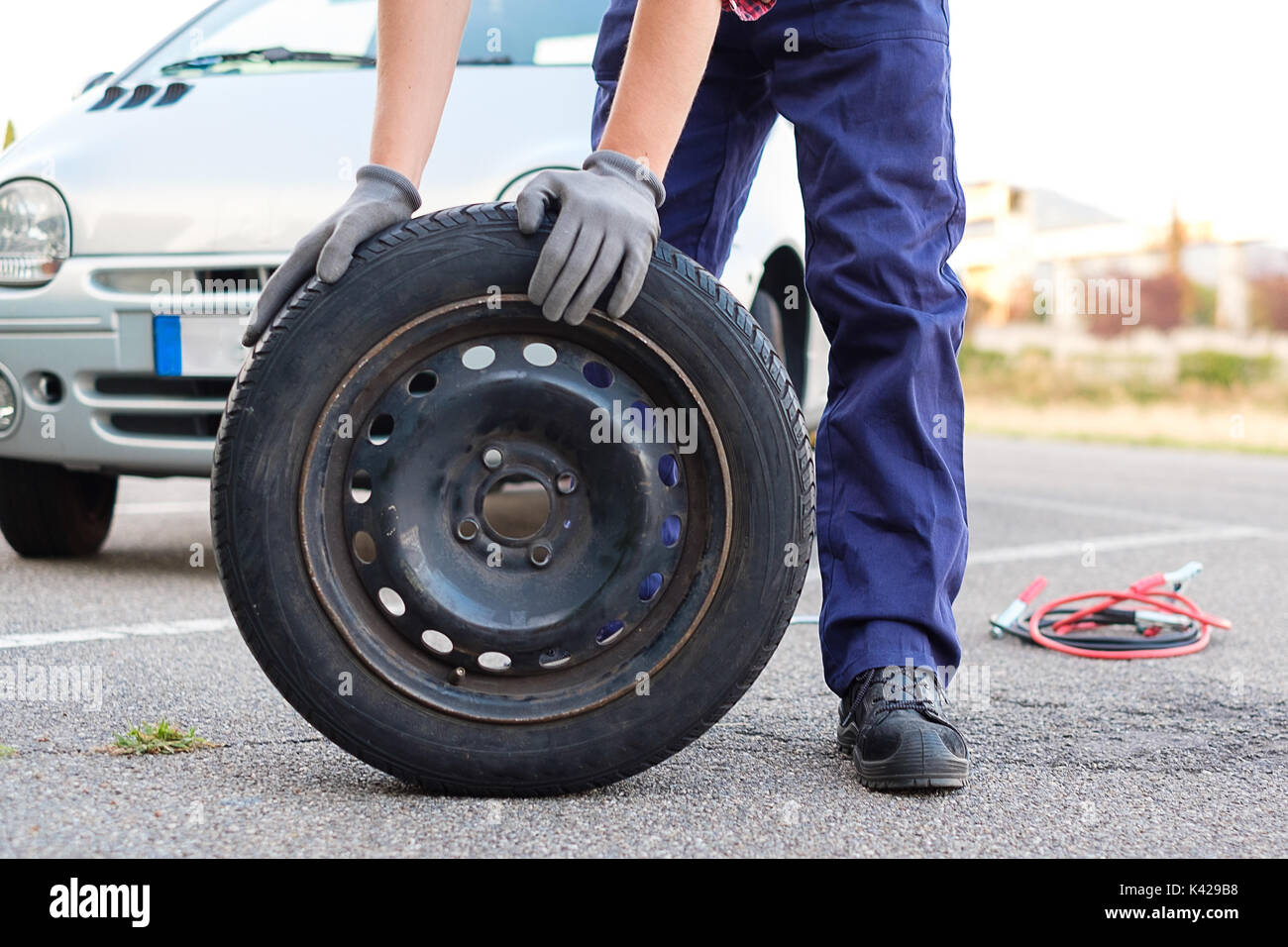 Man changing a flat tire on the side of the road Stock Photo Alamy