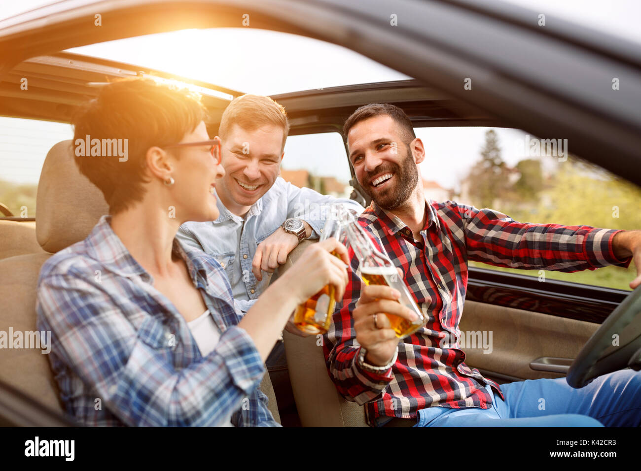 smiling friends having fun in the car on road trip Stock Photo