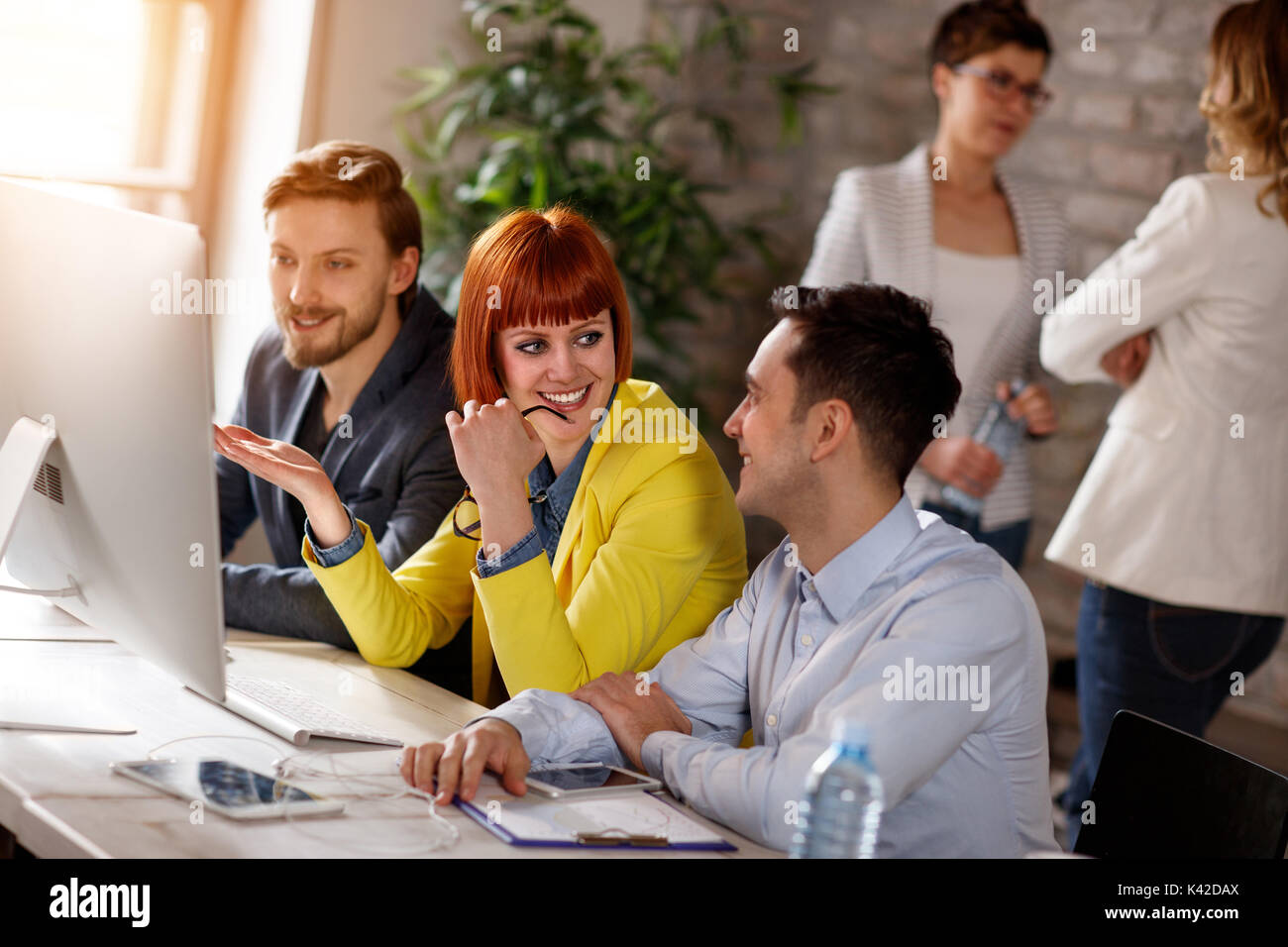 Group of young people working together on computer in office Stock Photo