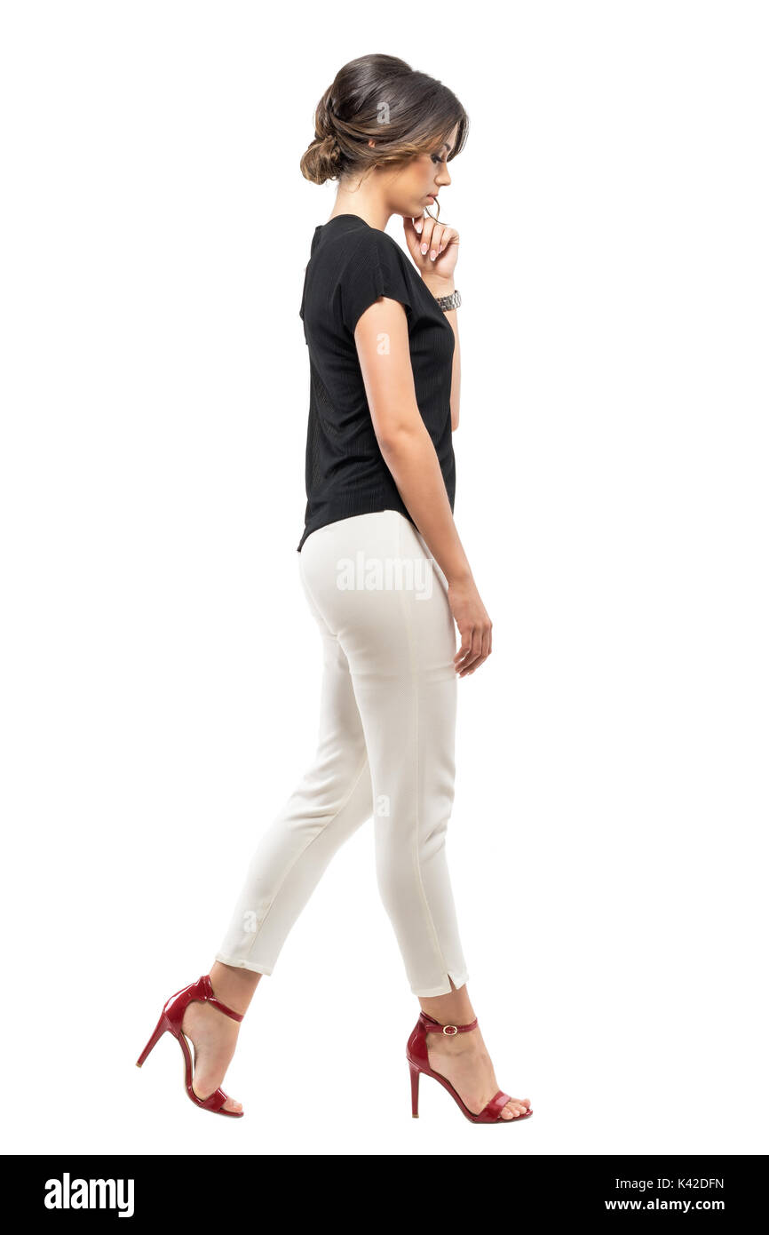 Side view of sad worried business woman in suit walking ...