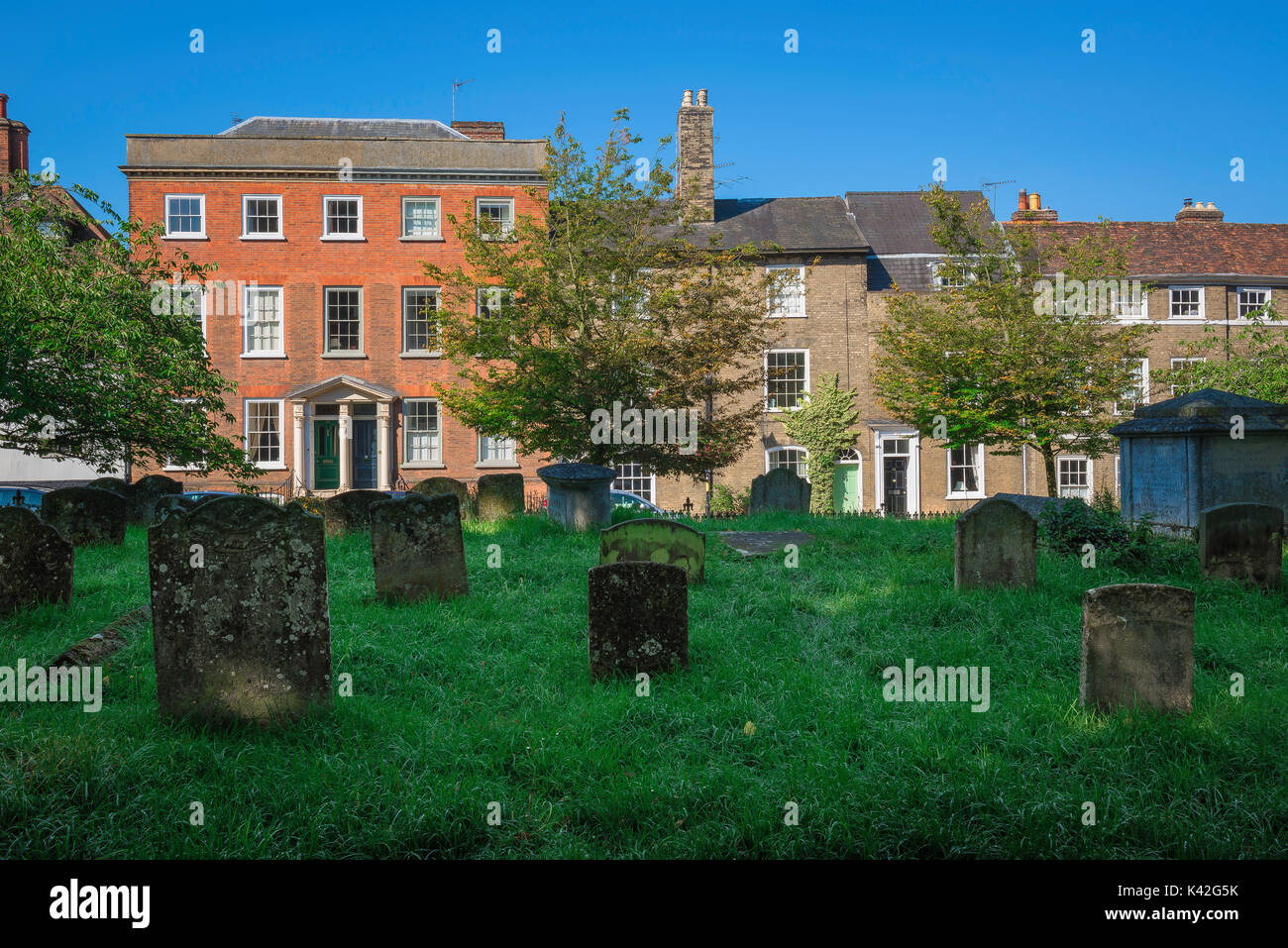 Bury St Edmunds Suffolk, contrasting view of St Mary's Great Churchyard and Georgian town houses in Crown Street, UK. Stock Photo