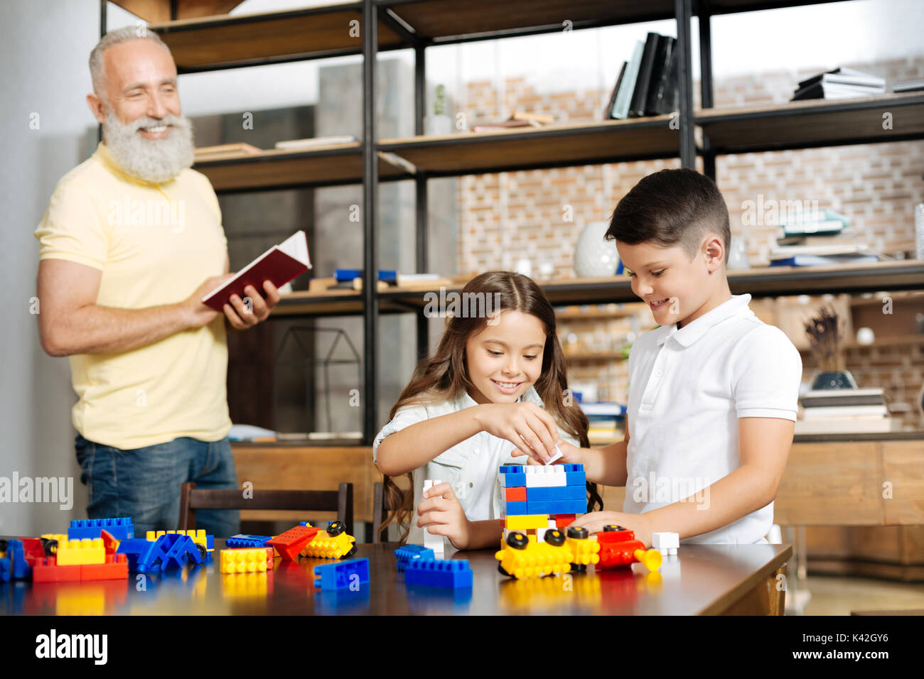 Adorable siblings building a tower with construction set Stock Photo ...