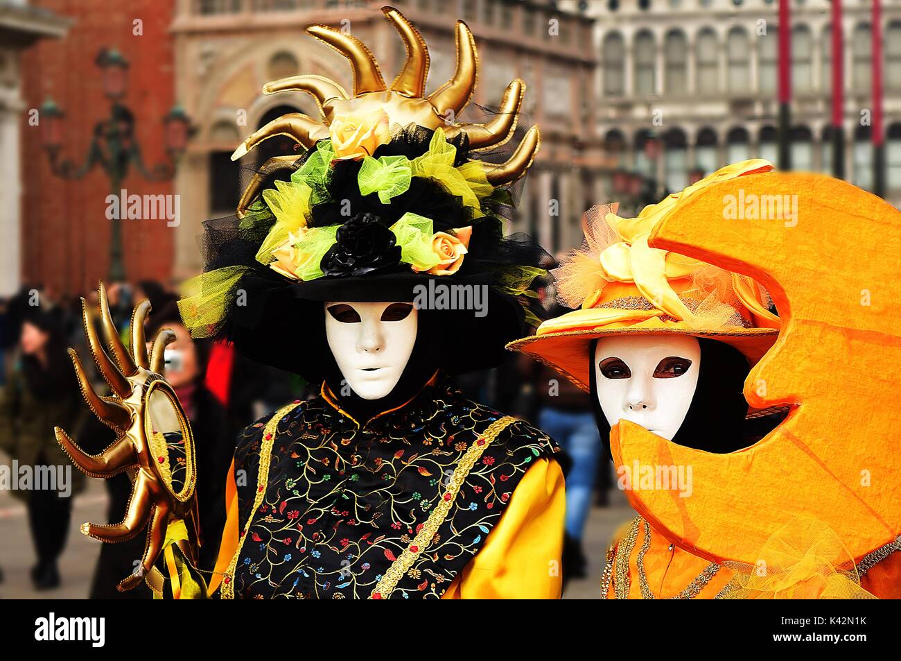Two people in costume during a masquerade at the Carnival of Venice, one as the sun, the other as the moon. Stock Photo