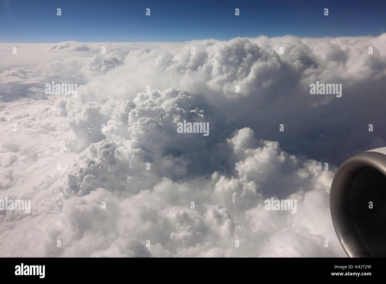 Motor of an airplane seen from window, flying above clouds. Stock Photo