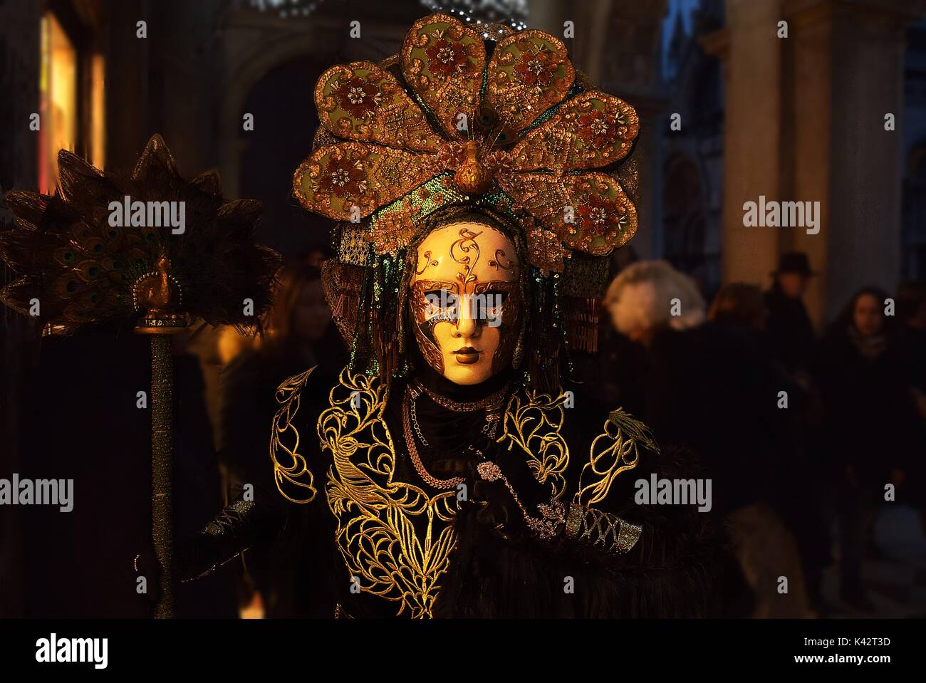 A person dressed in a costume resembling a peacock at a masquerade during the carnival of Venice. Stock Photo