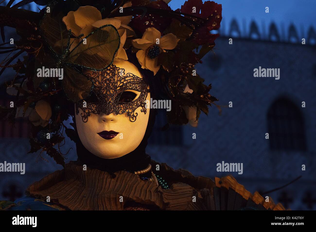 A Venetian masked masquerade in costume at the carnival of Venice Stock Photo