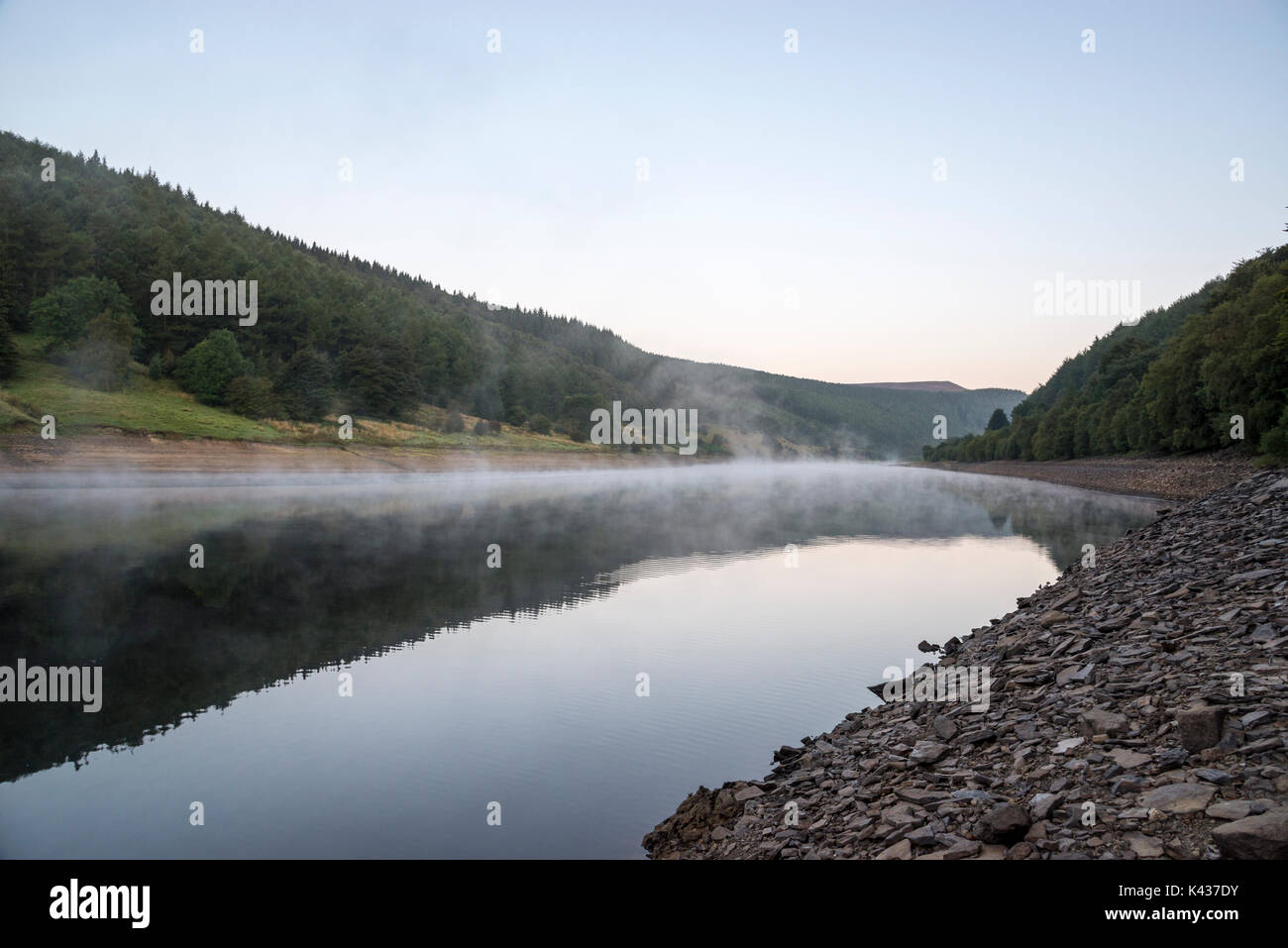 Stunning September morning at Ladybower reservoir, Peak District, Derbyshire, England. Mist drifting over the water surface. Stock Photo