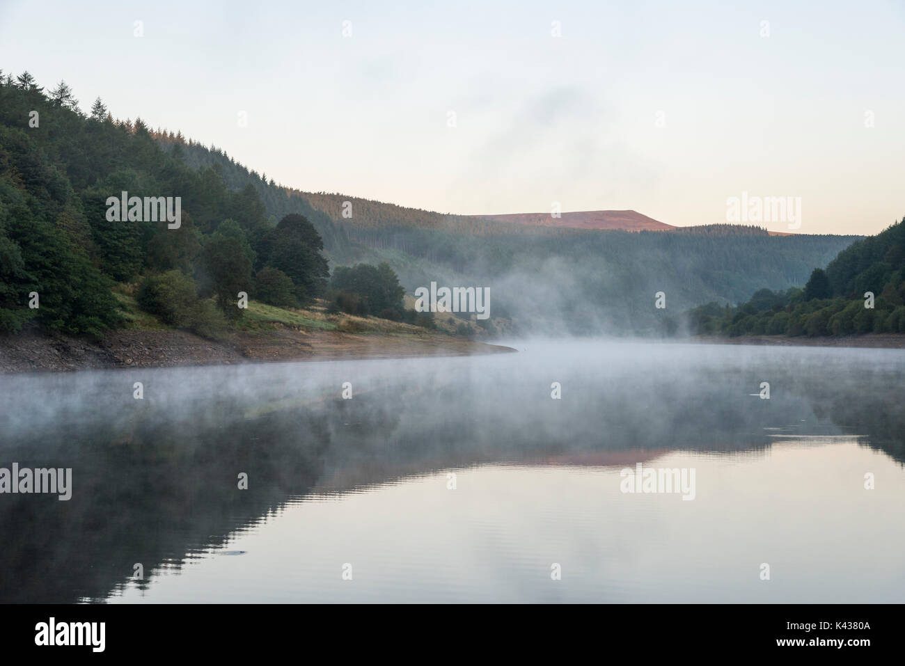 Stunning September morning at Ladybower reservoir, Peak District, Derbyshire, England. Mist drifting over the water surface. Stock Photo