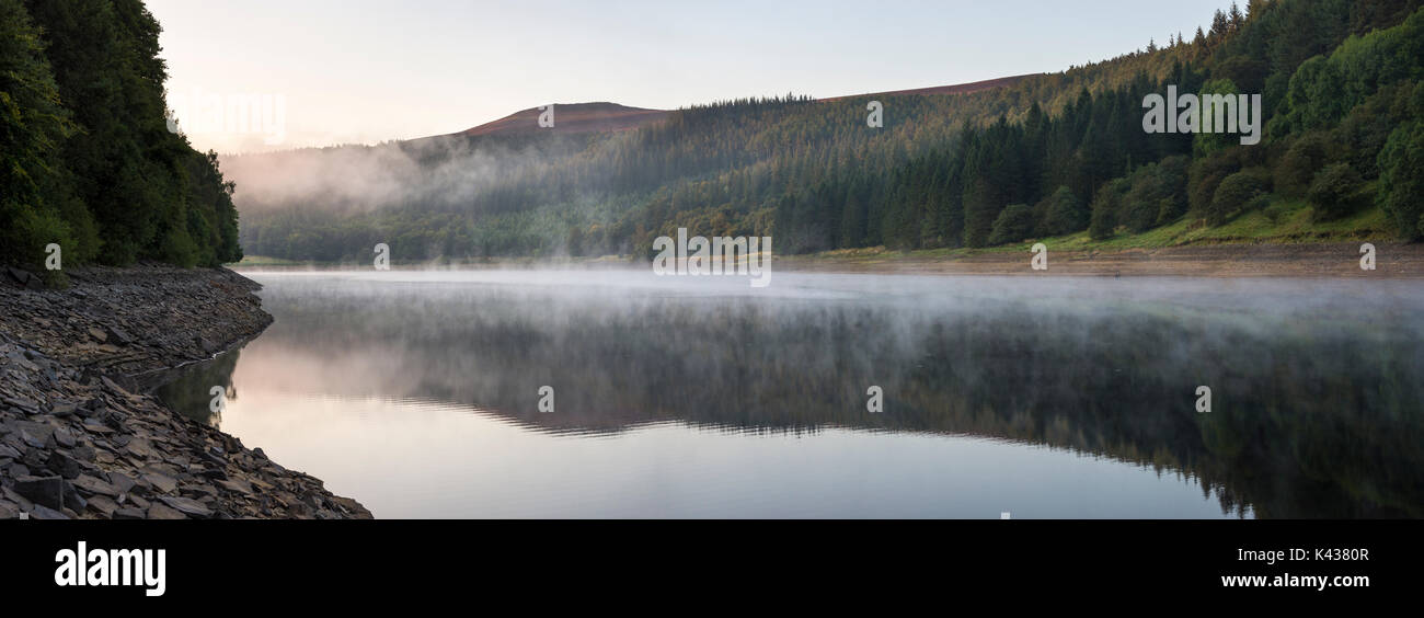 Stunning September morning at Ladybower reservoir, Peak District, Derbyshire, England. Mist drifting over the water surface. Stock Photo