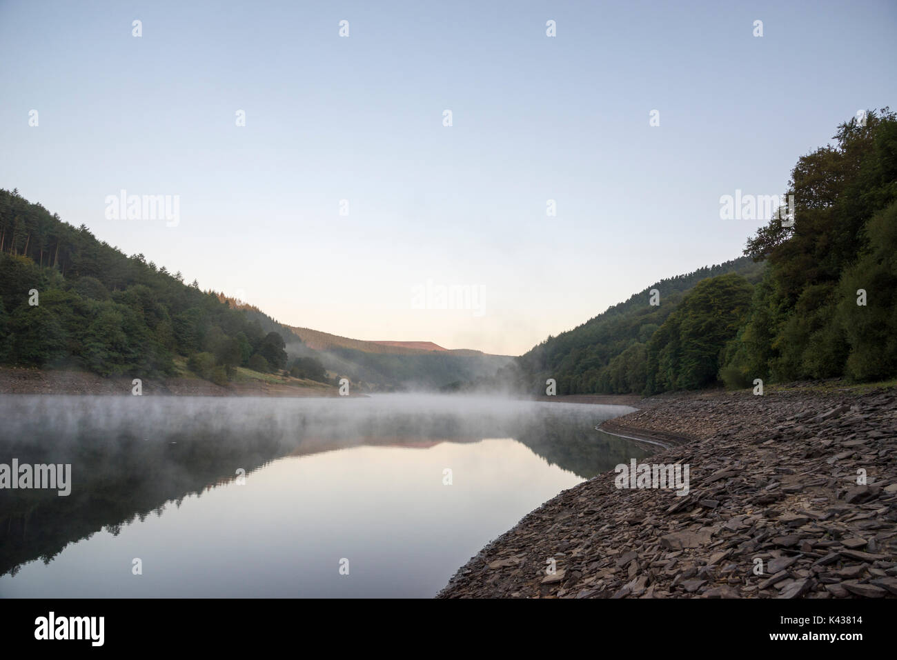 Stunning September morning at Ladybower reservoir, Peak District, Derbyshire, England. Mist drifting over the water surface. Stock Photo