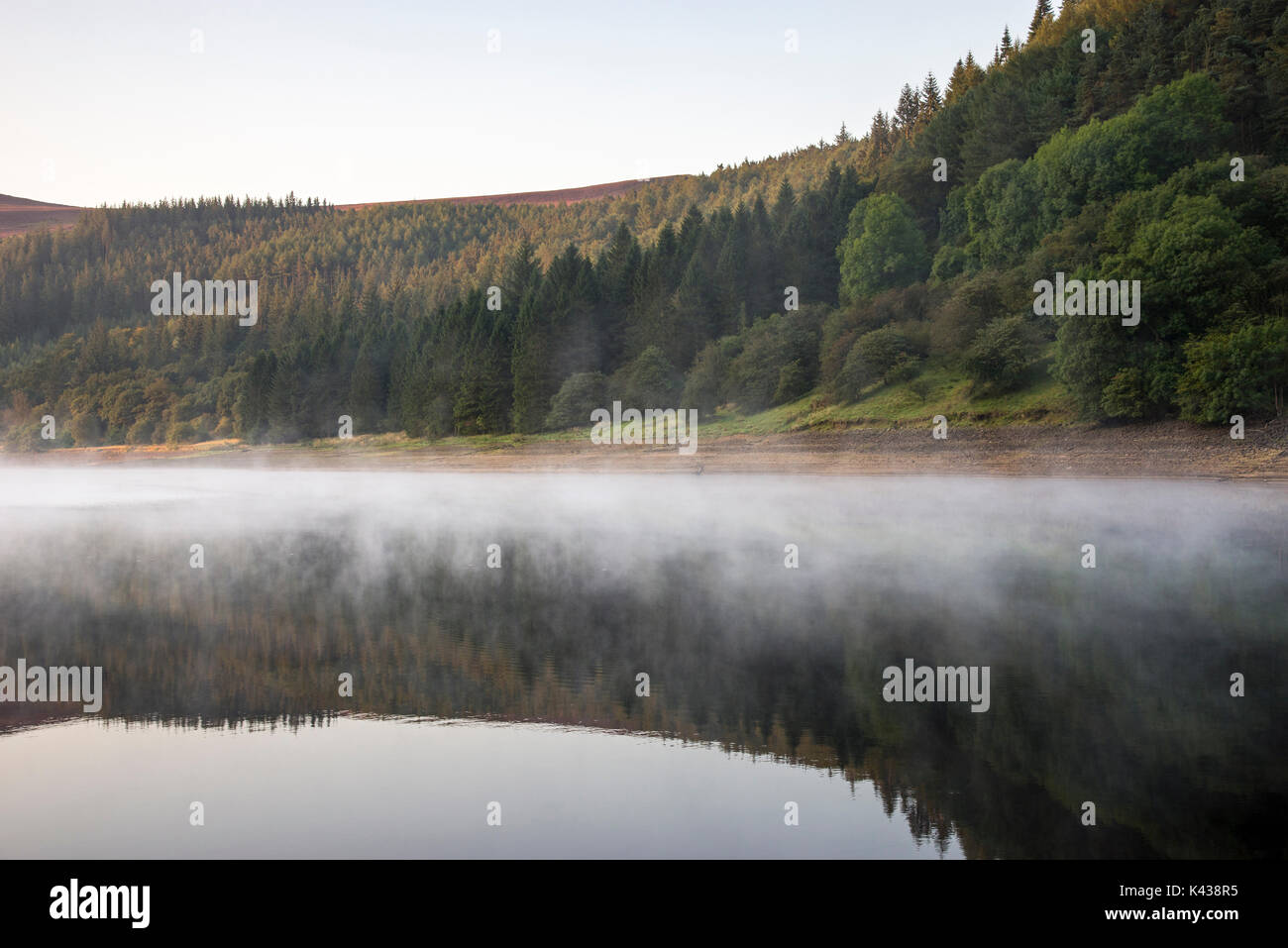 Stunning September morning at Ladybower reservoir, Peak District, Derbyshire, England. Mist drifting over the water surface. Stock Photo