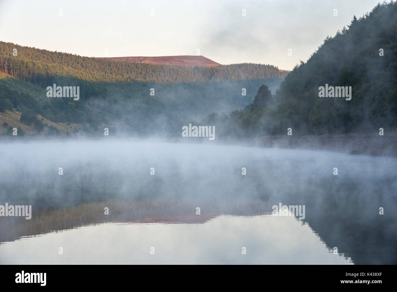 Stunning September morning at Ladybower reservoir, Peak District, Derbyshire, England. Mist drifting over the water surface. Stock Photo