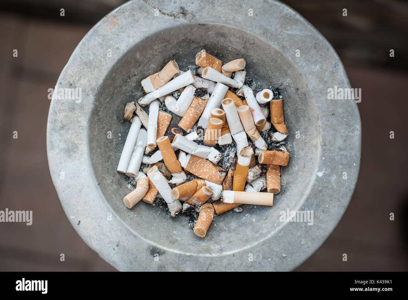 The dirty ashtray is full of cigarettes butt and ashes. Real life scene
