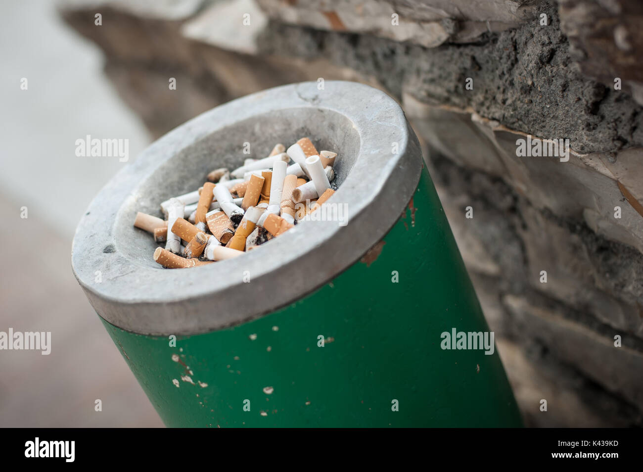 The dirty ashtray is full of cigarettes butt and ashes. Real life scene