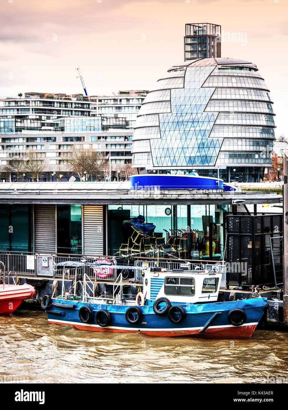 Old boat moored on the Thames and the London City Hall Stock Photo