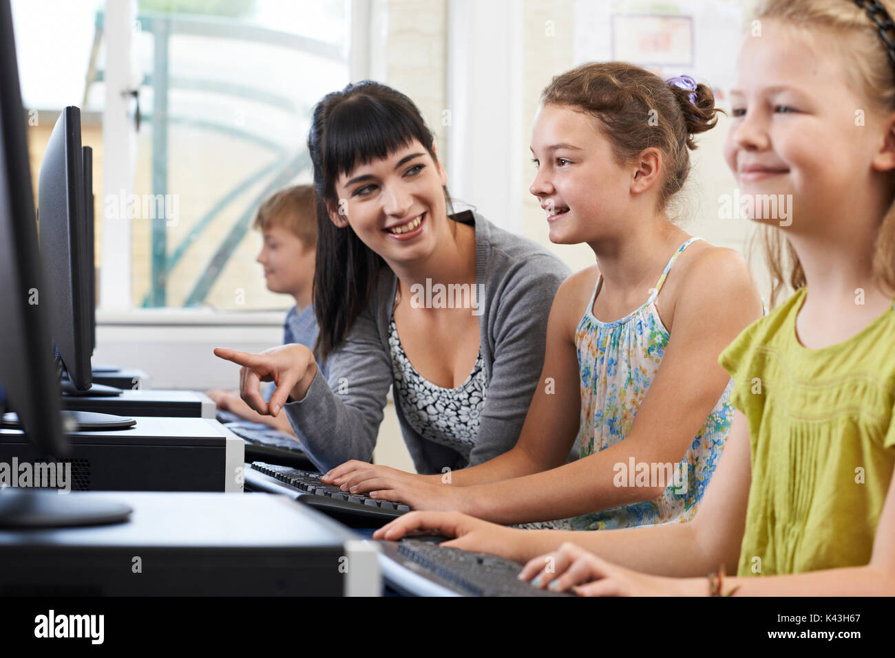 Female Elementary Pupil In Computer Class With Teacher Stock Photo - Alamy