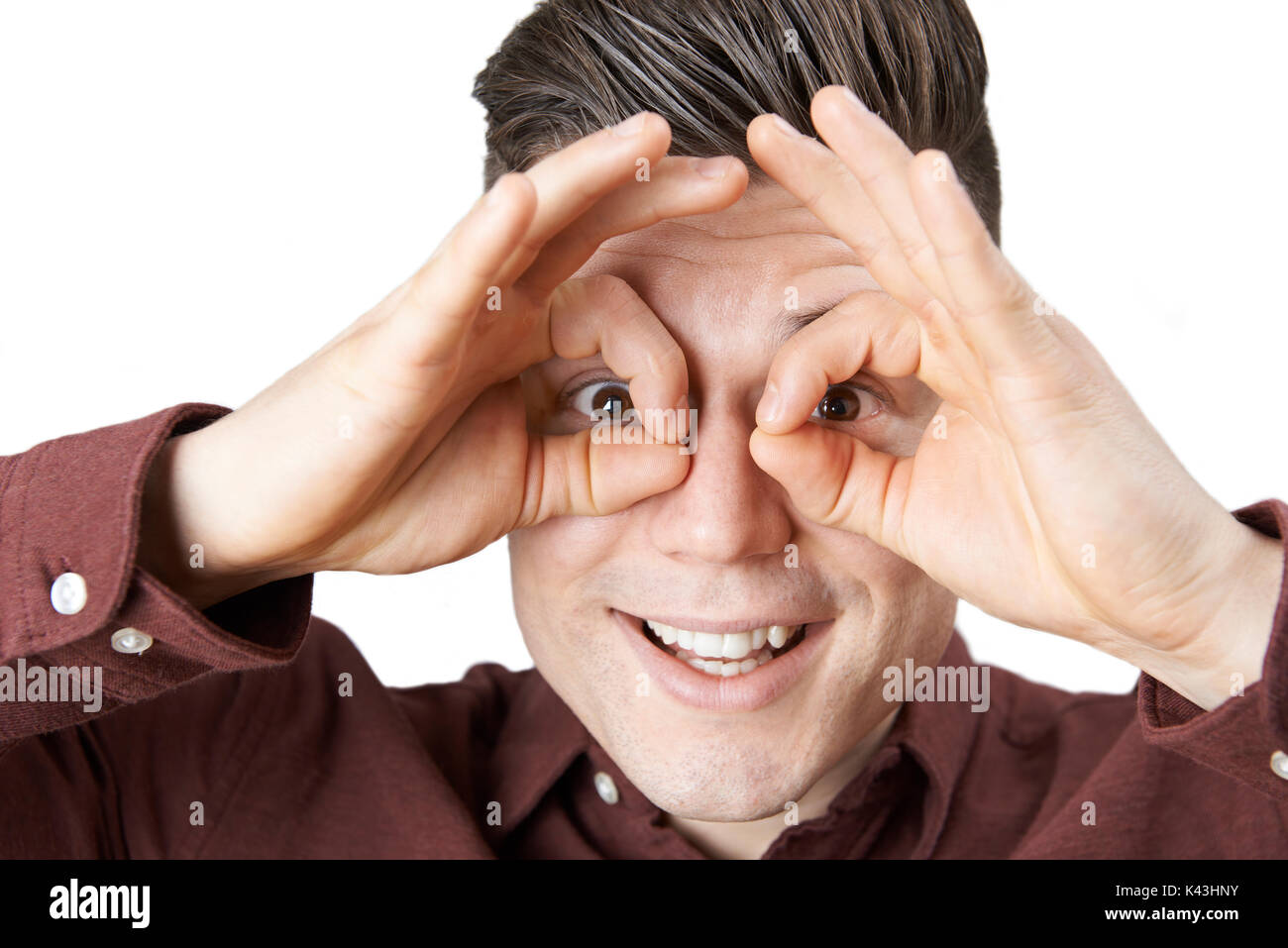 Studio Shot Of Man Making Spectacle Shape With His Hands Stock Photo
