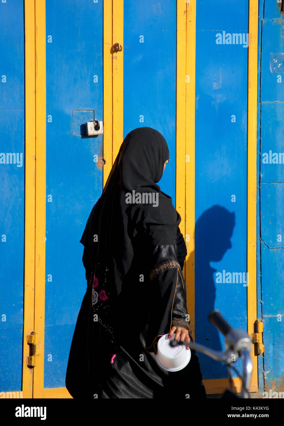 Iranian woman in chador and accompanying shadow (of a man), Shiraz Stock Photo