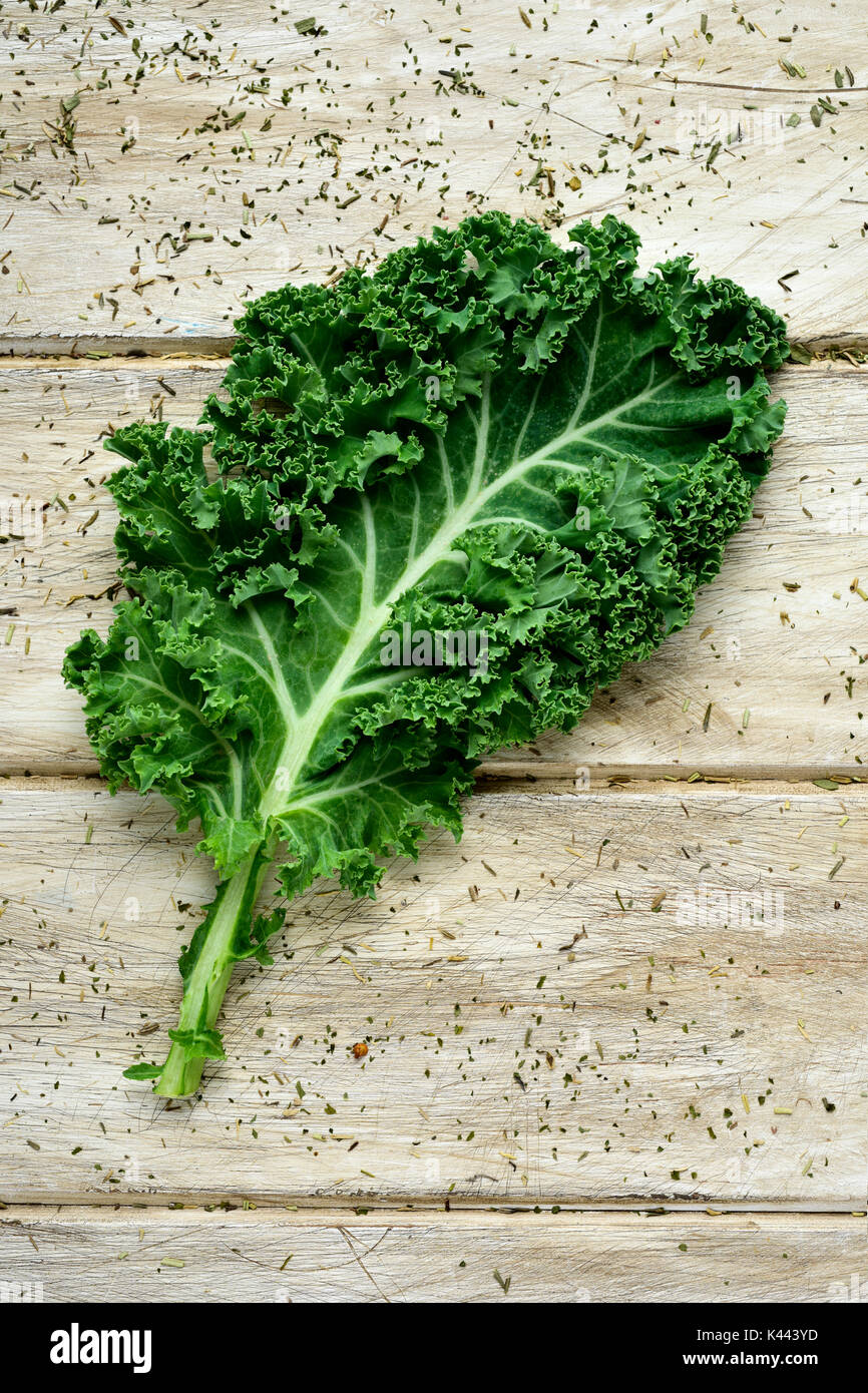 closeup of a kale leaf on a rustic wooden table Stock Photo