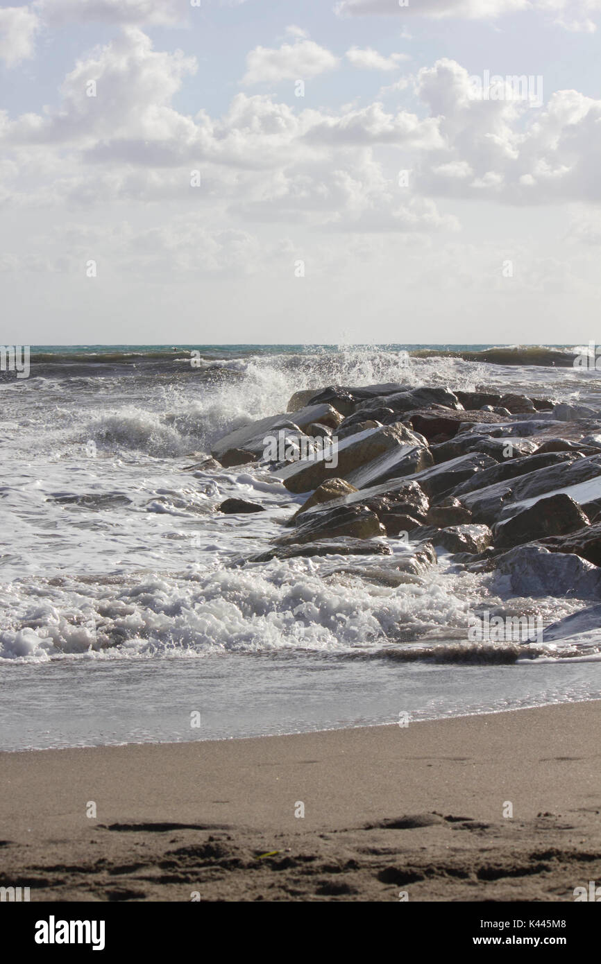 MARINA DI MASSA, ITALY - AUGUST 17 2015: Waves crashing into rocks in Marina di Massa, Italy Stock Photo