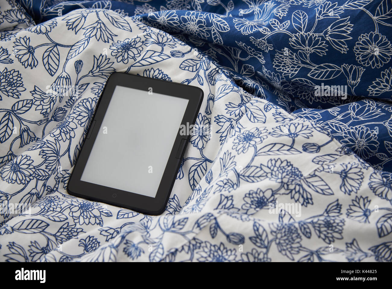 ebook device with blank screen on a blanket. The e-book device is a dedicated device for reading e-books. Stock Photo