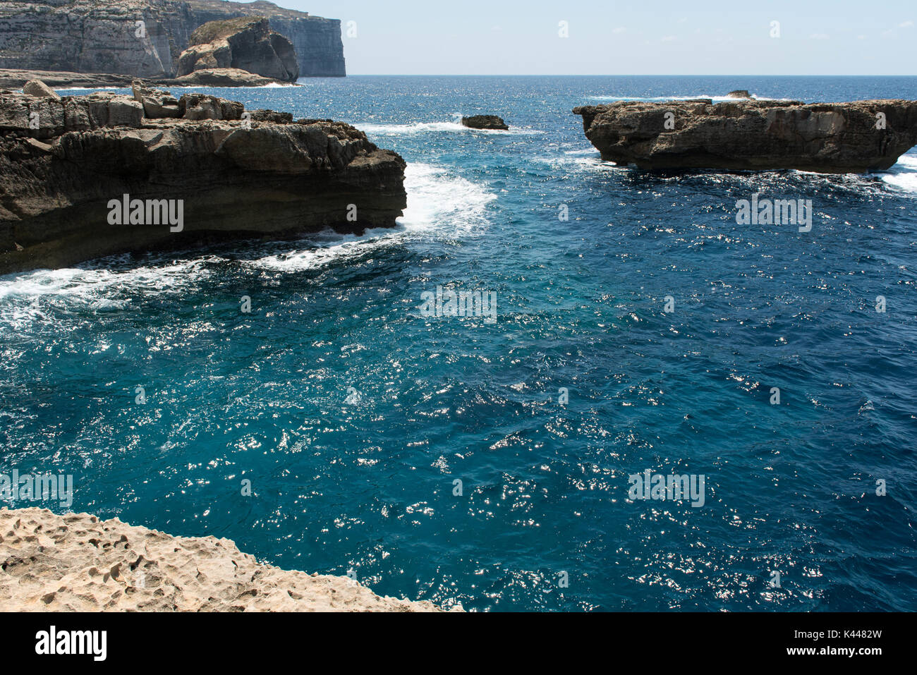 Rocky coastline and sea. Blue hole and the collapsed Azure window in Dwejra Bay, Gozo, Malta Stock Photo