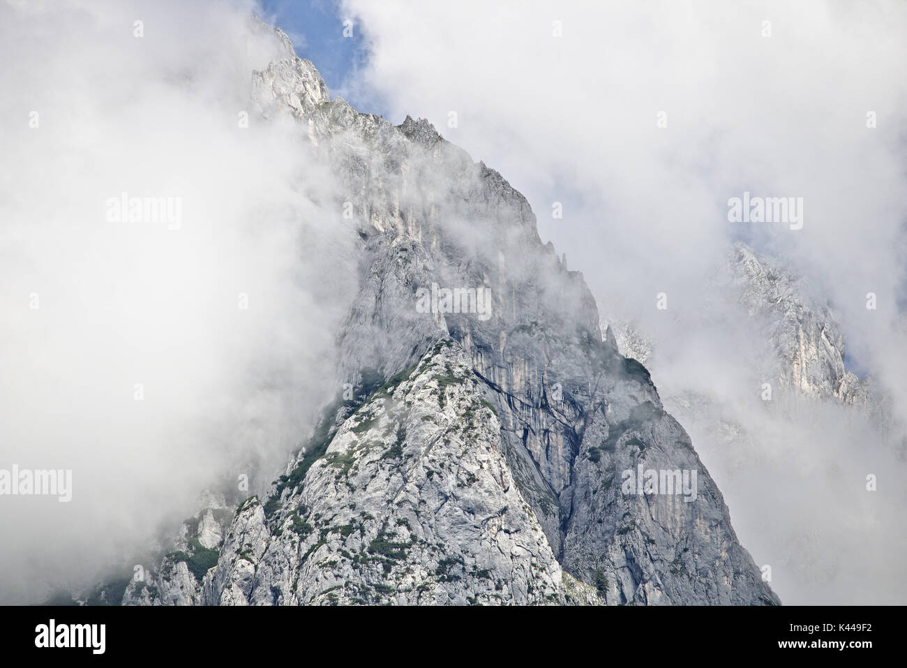 Rocky steep slope of a mountain partly covered by mist in the Tennen range in the Austrian Alps near the town of Werfen Stock Photo