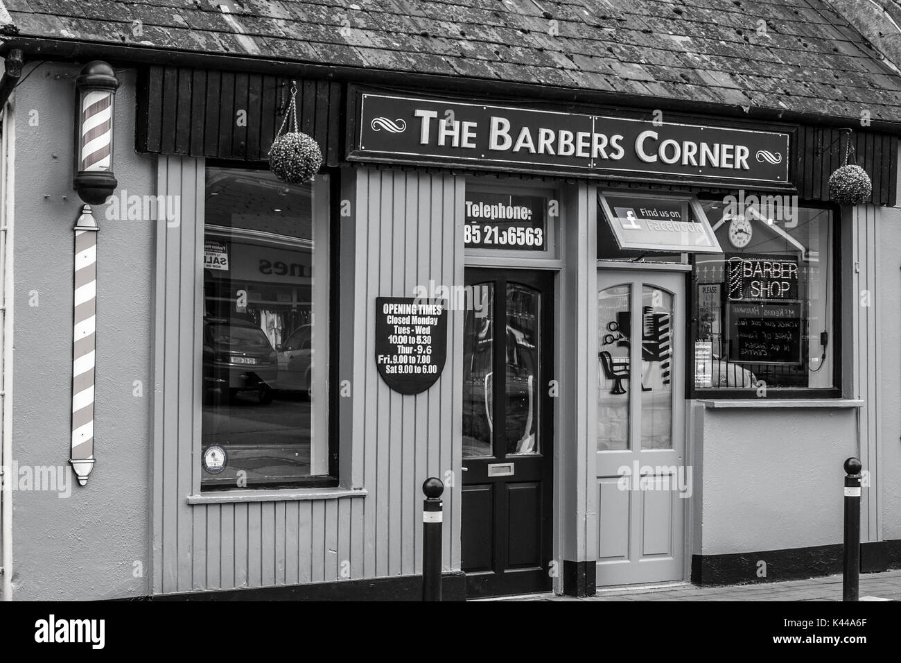 Barber Shop Front with Red and White Pole in Co.Clare Ireland in black and white Stock Photo