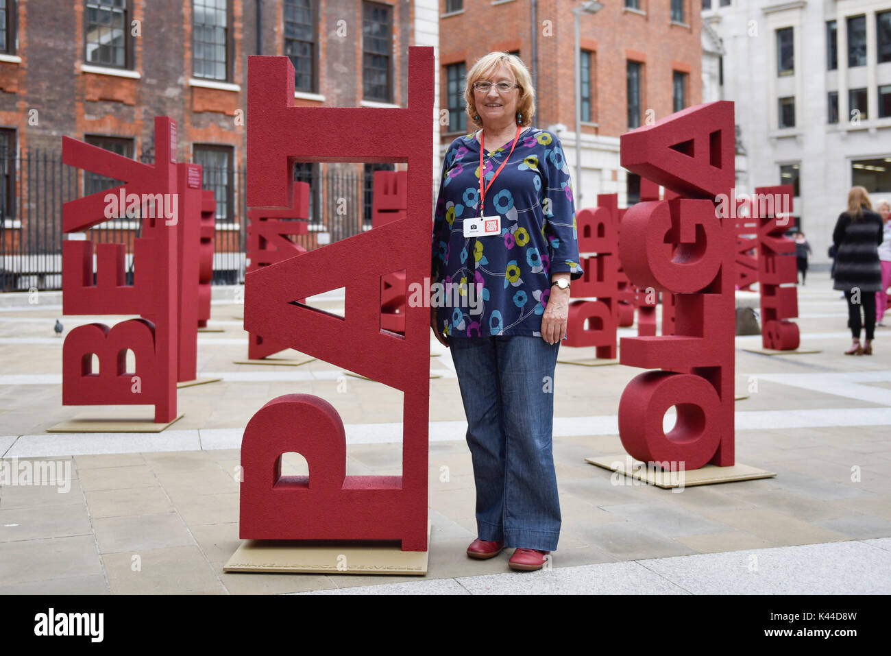 London, UK.  4 September 2017. Blood cancer sufferer Pat, aged 72, stands with her name. 104 three dimensional names have been installed in Paternoster Square near St. Paul's cathedral to mark the launch of the 'Make Blood Cancer Visible' campaign.  Designed by Paul Cocksedge, the typographic forest of names represents the 104 individuals diagnosed with blood cancer daily.  Each piece symbolises an individual with blood cancer, the height corresponds to the height of that individual and bears a write-up of their particular type of blood cancer.   Credit: Stephen Chung / Alamy Live News Stock Photo