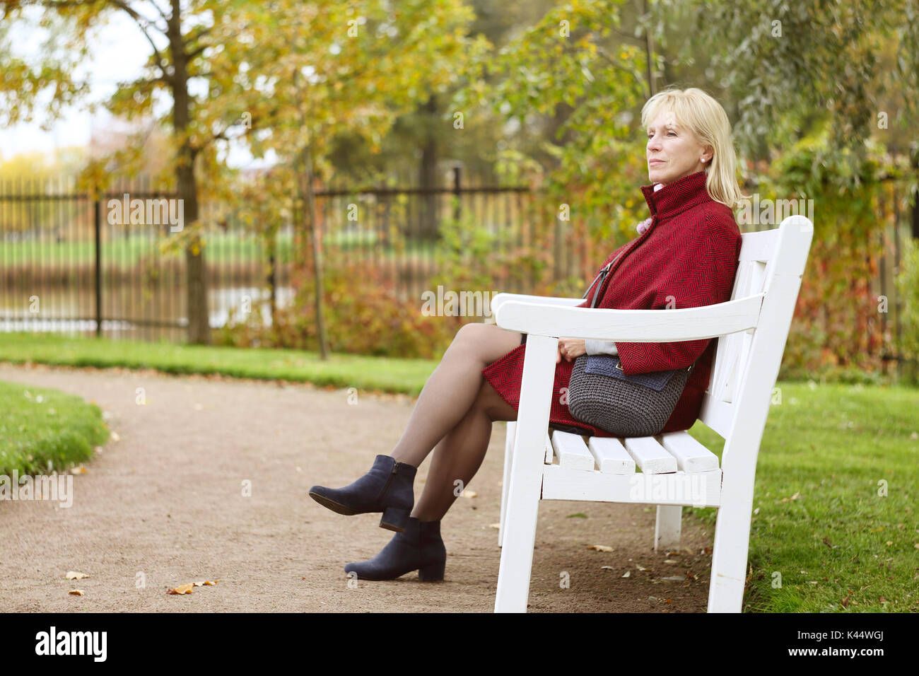 Senior citizen sitting on a park bench in autumn hi-res stock ...