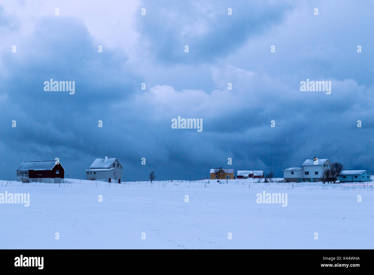Clouds on the village of fishermen surrounded by snow at dusk Flakstad Lofoten Islands Norway Europe Stock Photo