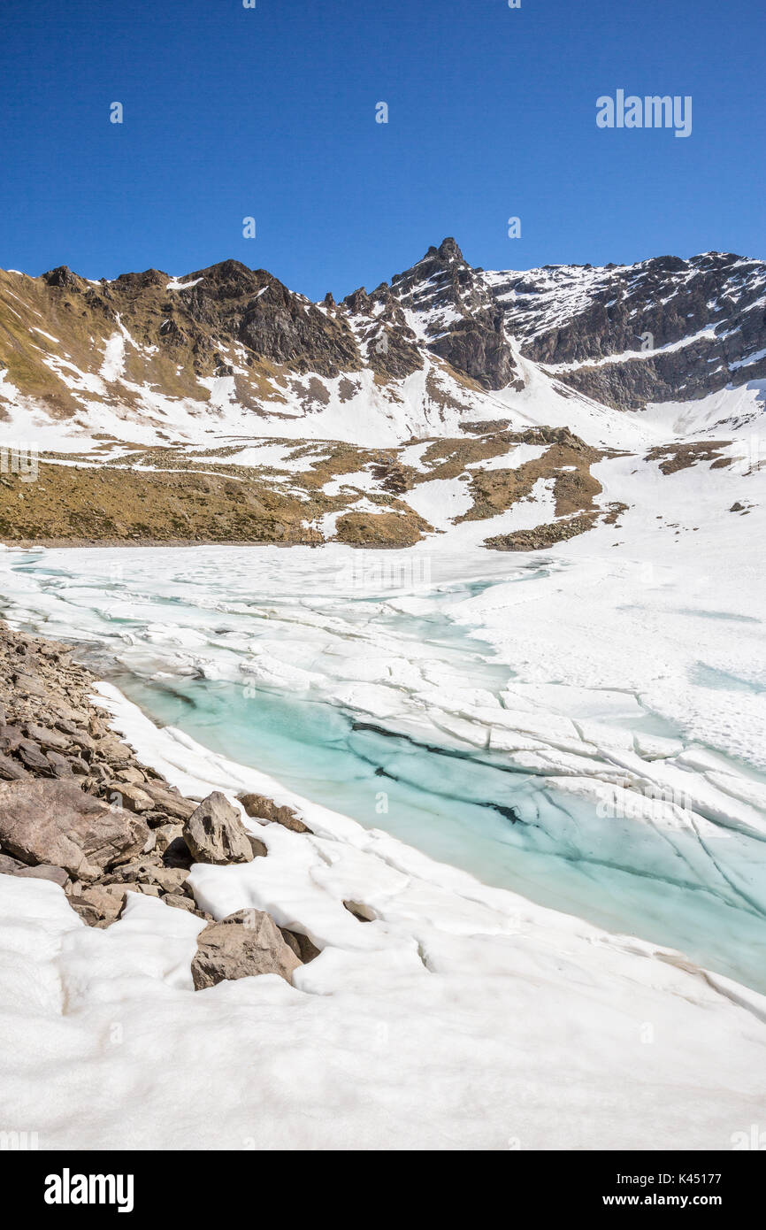 The spring thaw reveals the turquoise water of Laj dal Teo Poschiavo Valley Canton of Graubunden Switzerland Europe Stock Photo
