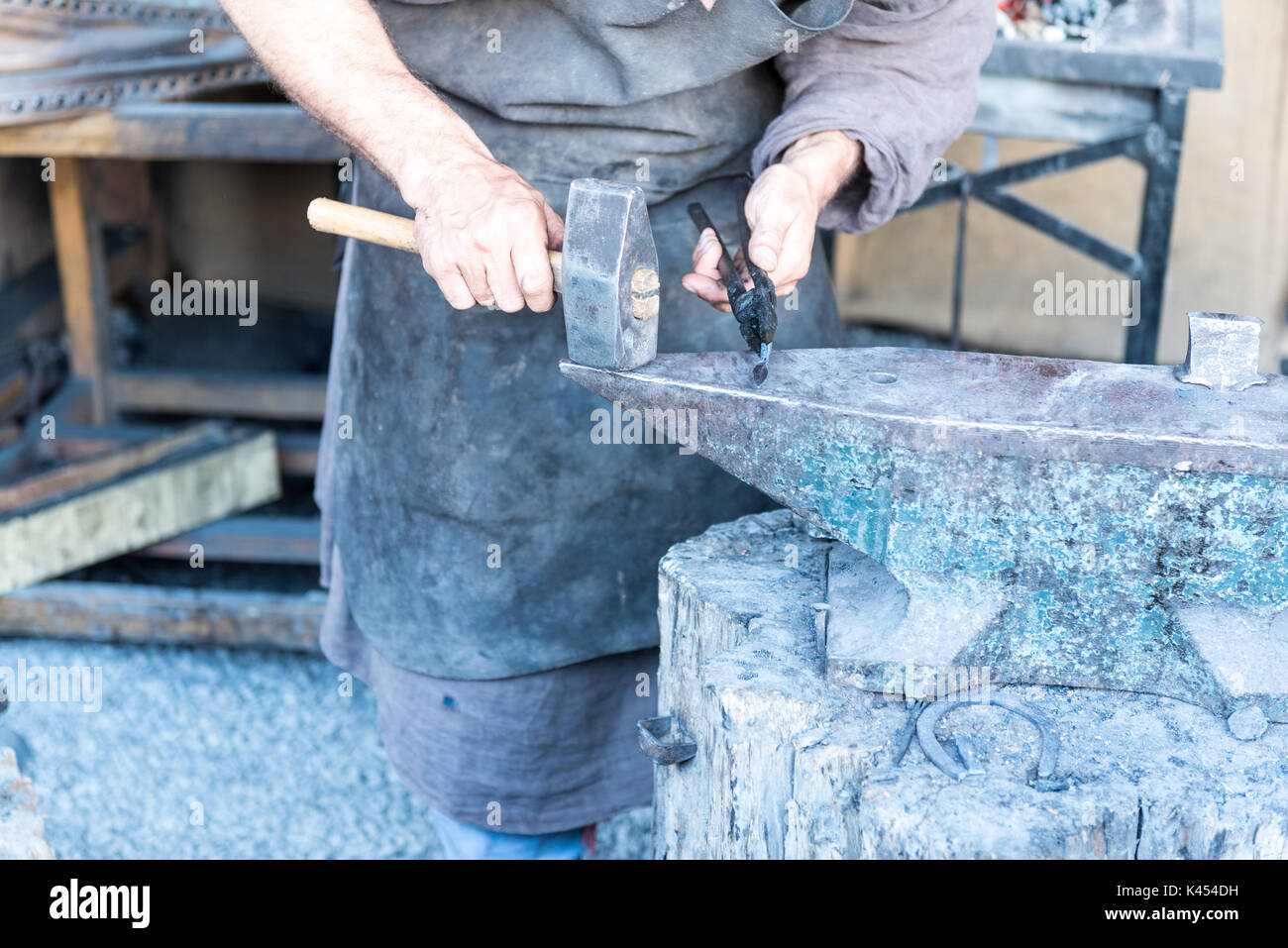 The blacksmith the molten metal on the anvil in smithy Stock