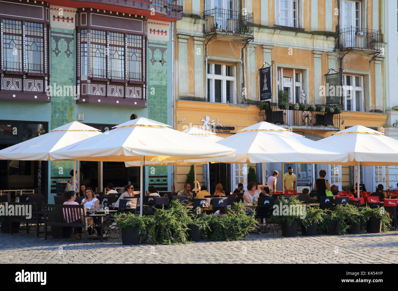 Cafes by the historic pastel-hued buildings on Union (Unirii ) Square, in Timisoara, western Romania, east Europe Stock Photo