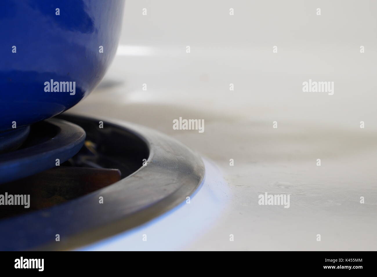 A blue ceramic colourfully enameled castiron cookware pot on a stove