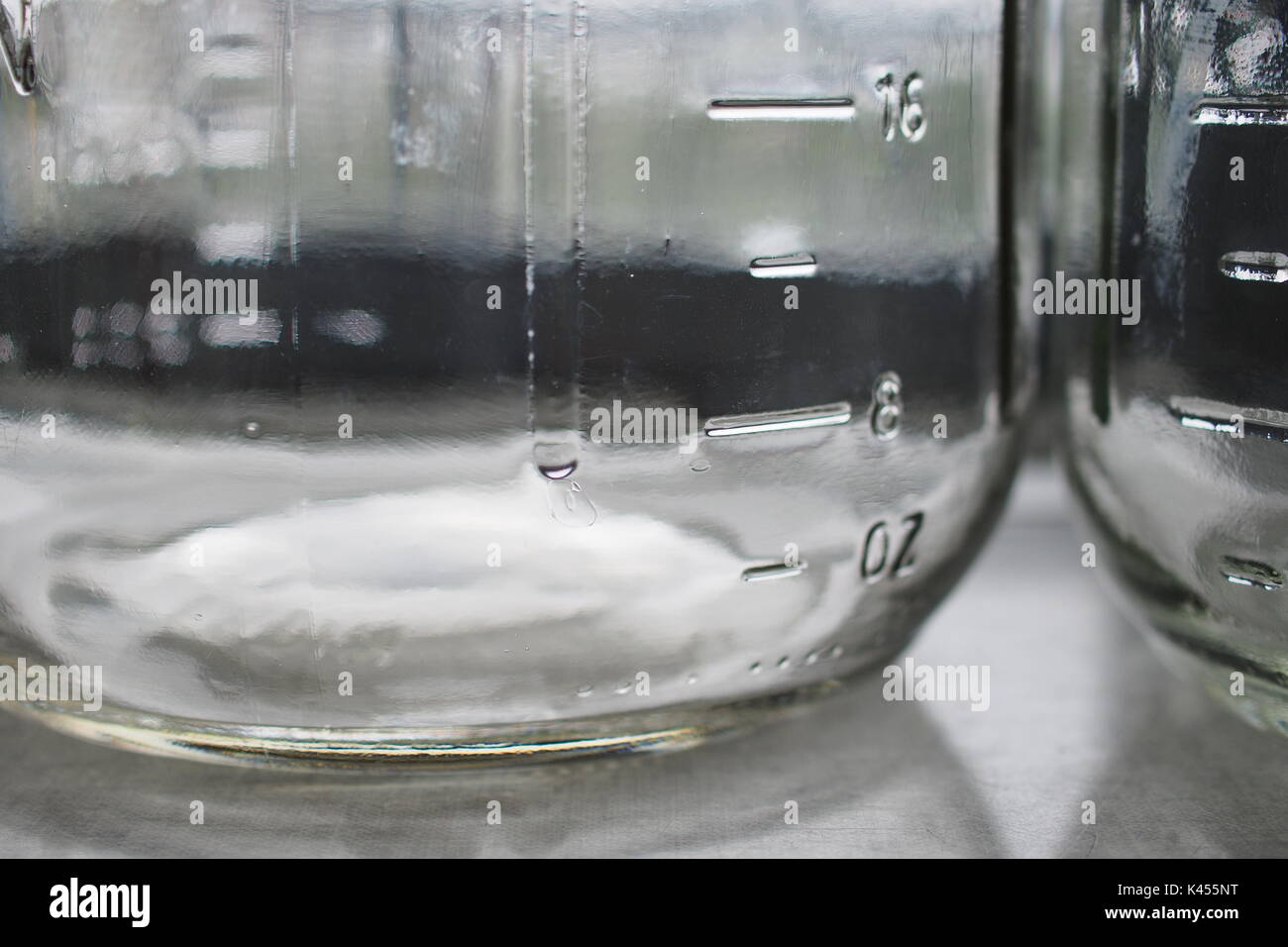 https://c8.alamy.com/comp/K455NT/close-up-of-two-glass-storage-mason-jars-on-a-ledge-showing-the-liquid-K455NT.jpg
