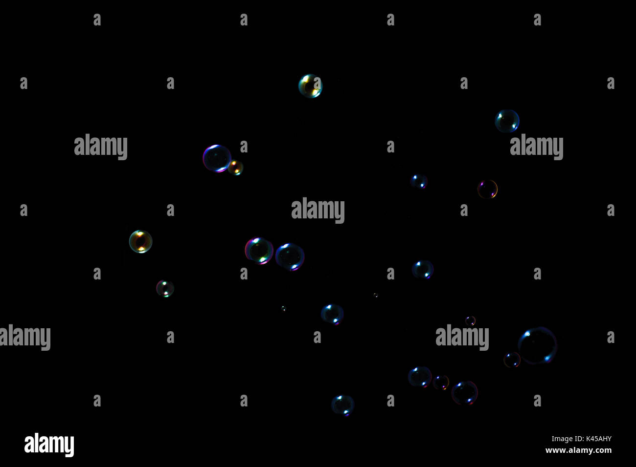 Rainbow soap bubbles on a dark background. Stock Photo