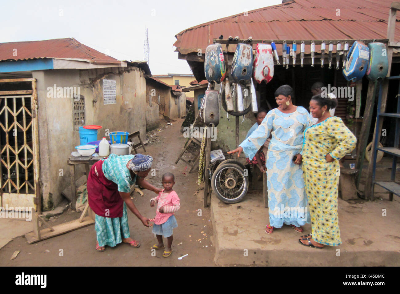 Nigerian woman and girl in front of spare parts in the city of Akure, capital of Ondo State in Nigeria Stock Photo