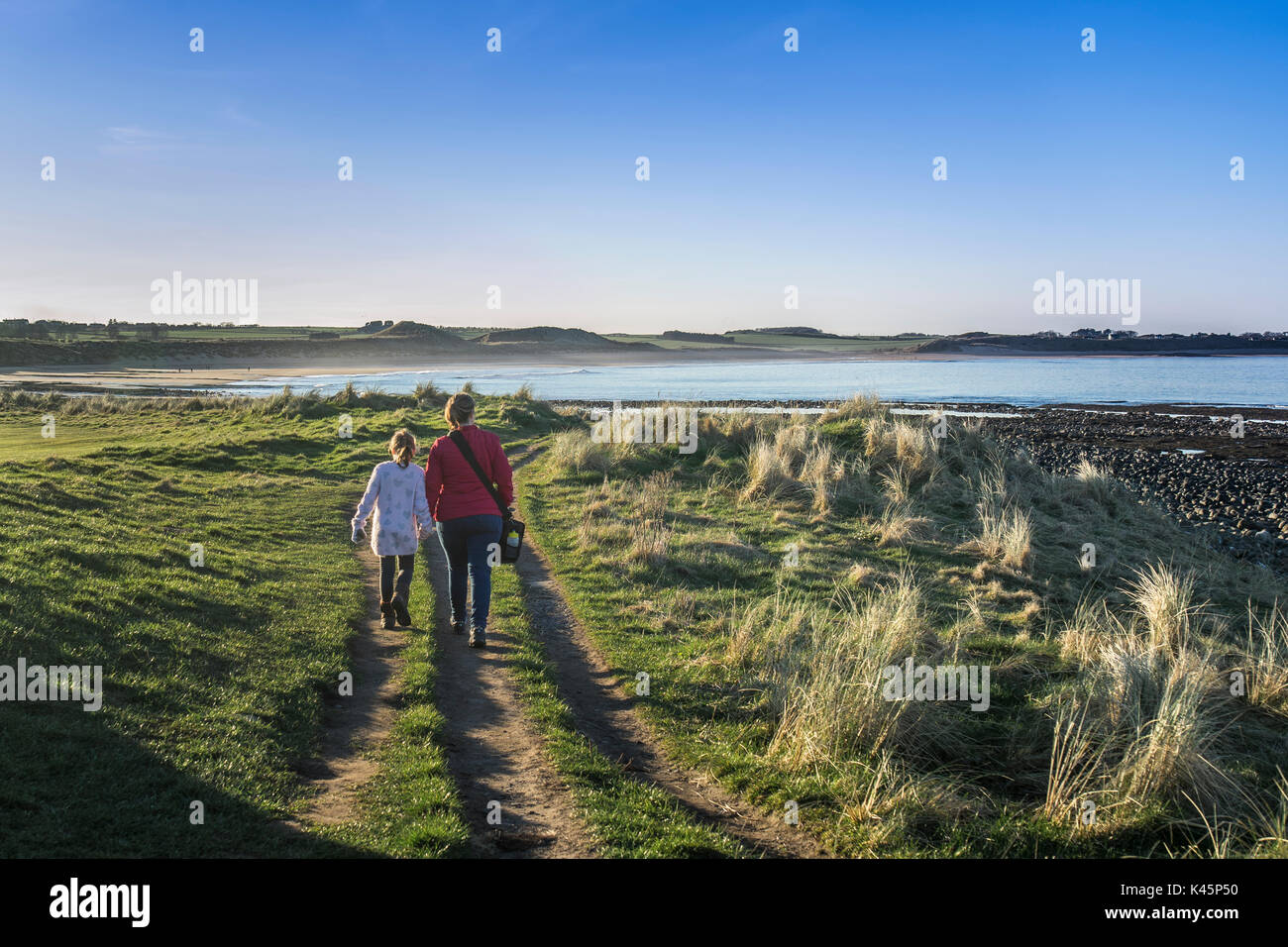 Mother and Daughter take a Coastal Walk by the Sea Stock Photo